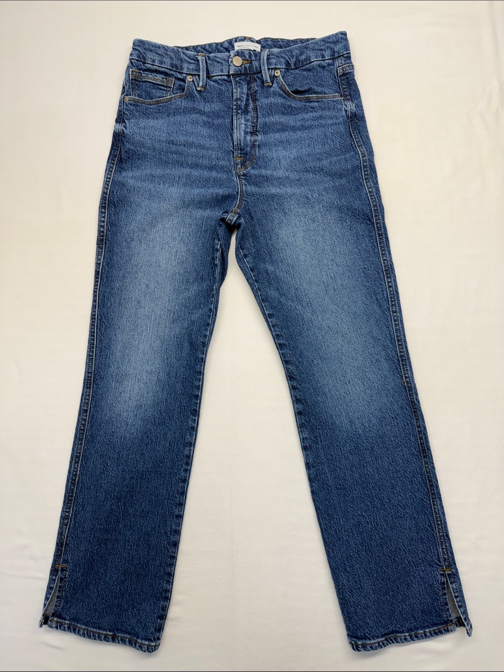 Good American straight-leg jeans in a mid-to-dark blue wash